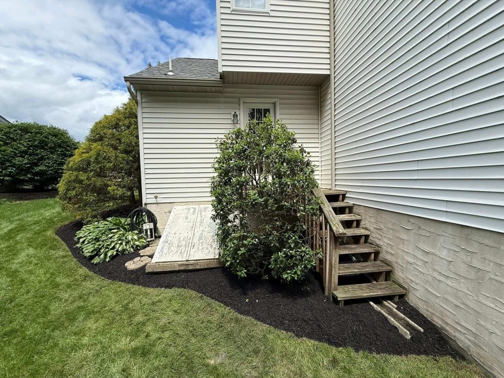 trimmed mulch garden beds back entrance